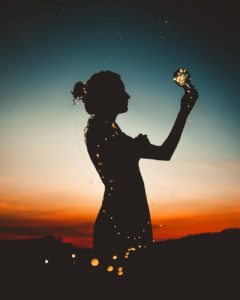 woman holding lit up light string silhouette photography